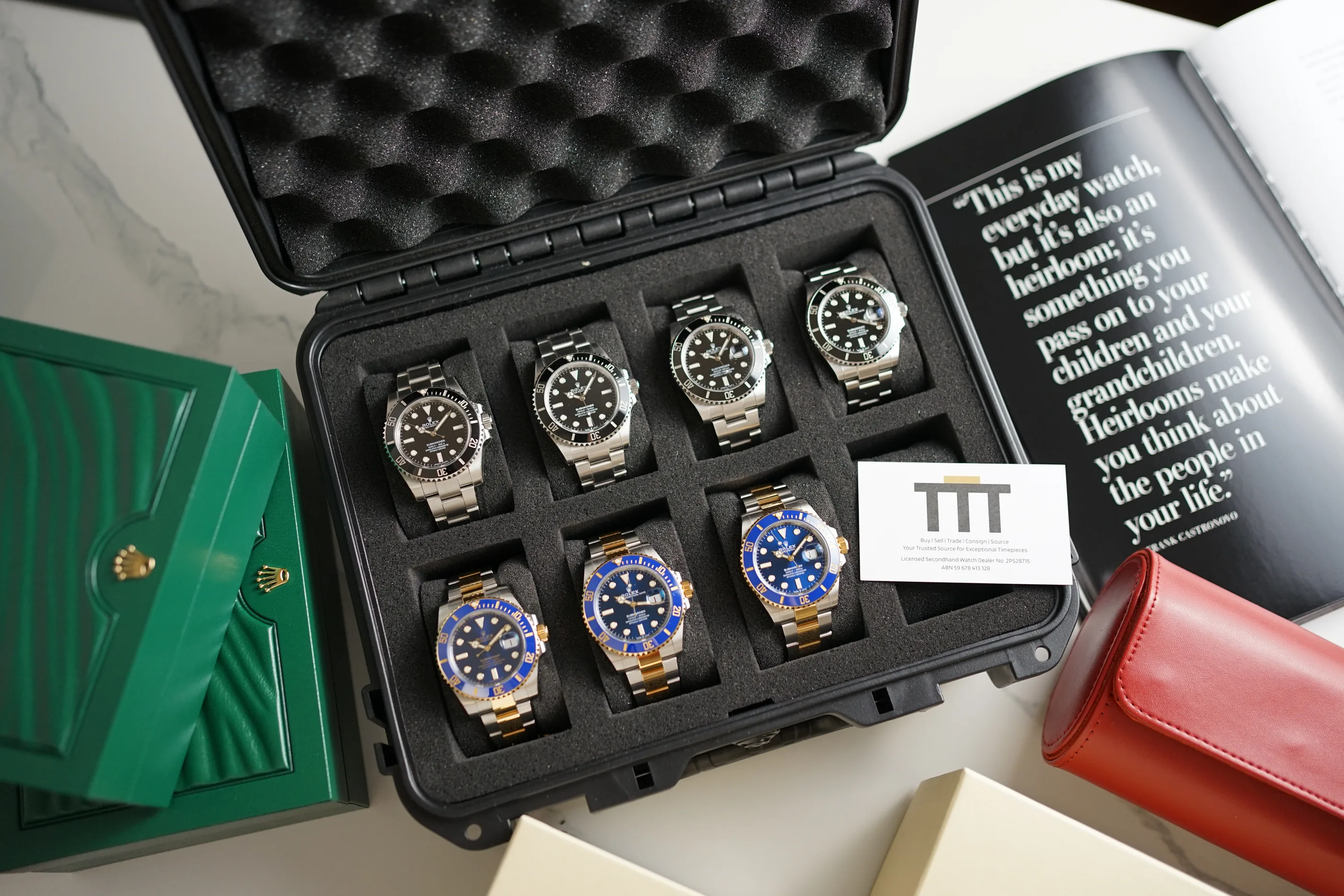A case of Rolex Submariners with the Tell the Time Co. card, alongside a Rolex box and watch roll